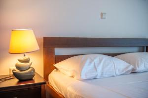a bedroom with a bed with a lamp on a night stand at Apartments Melisa in Ulcinj