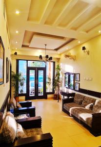 a living room with couches and tables in a room at Shelton Hotel & Restaurant in Sarai