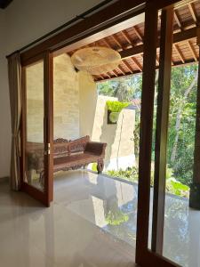a bench in front of a door with a window at The Alus Cottage and Villa in Ubud