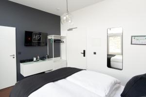 1 dormitorio con cama blanca y espejo en Hotel Deluxe, en Dorsten