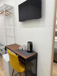 a small table with a microwave and a yellow chair at Maison Angioino in Naples