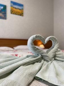 a towel in the shape of a heart on a bed at Ca' Del Diaolo in Badia Calavena +4 photos