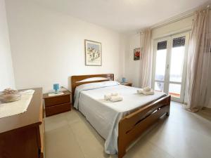 una camera da letto con un letto e due asciugamani di Nuovo Appartamento Ristrutturato in Corte Interna a La Maddalena
