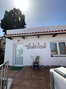 a white building with a sign that reads stichato at Strelitzia Apartament in Santa Úrsula