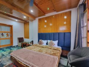een slaapkamer met een groot bed met een blauw hoofdeinde bij Green View By Wow Hotels in Banikhet
