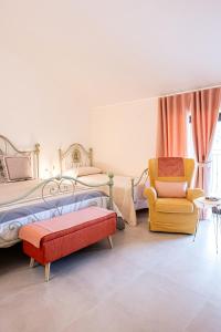 - une chambre avec un lit et une chaise dans l'établissement AgriBio Villa Ribes, à Altamura