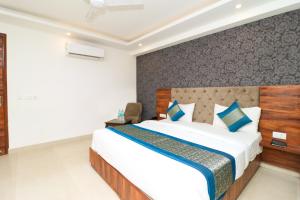 a bedroom with a large bed with blue pillows at Hotel Vertu IGI Delhi Airport By OPO - FREE Airport Pick Up Or Drop in New Delhi