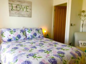 a bedroom with a bed with a floral comforter at Sunsets, Sandylands Prom Morecambe in Morecambe