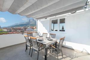 a dining room with a table and chairs on a balcony at Apartman L&L in Makarska