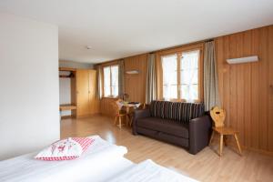 een slaapkamer met een bed en een bank in een kamer bij Hotel Kurhaus Heiligkreuz in Heiligkreuz