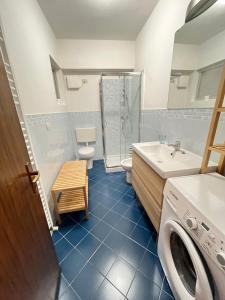 a bathroom with a toilet sink and a washing machine at Appartamento Warner in Grado