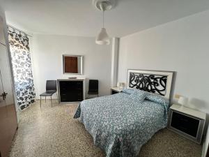 1 dormitorio con 1 cama y 2 sillas en Vigalpe Valdelagrana 10, en El Puerto de Santa María