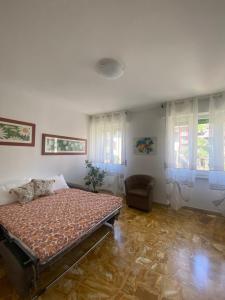 una camera da letto con un letto, una sedia e finestre di Sole , Neve e Relax a Clusone