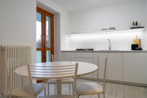 - une cuisine avec une table et des chaises dans la chambre dans l'établissement Vista Dolce Isola _ Lakeview Pool, Terrace & Garden apartment, à Argegno