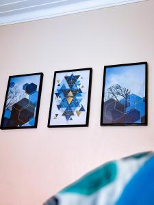 a row of four framed art on a wall at GEORGE’S PLACE in Kira