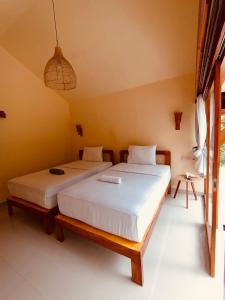 1 dormitorio con 2 camas en una habitación en Waroeng Senaru, en Senaru
