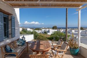 a patio with a table and chairs on a balcony at Marpissa Paros house Casa Mira in Kampos Paros