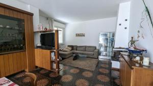 ein Wohnzimmer mit einem TV und einem Sofa in der Unterkunft Appartamento zona Grazie in Ancona