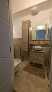 ein Badezimmer mit Waschbecken, Toilette und Spiegel in der Unterkunft Appartamento zona Grazie in Ancona