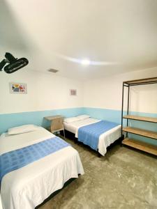 two beds in a room with blue walls at Hotel Anauco in Bucaramanga