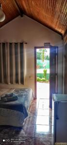 a bedroom with a bed and a sliding glass door at Pousada Recanto das Maritacas in Brotas