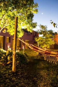 a hammock in a yard next to a building at Refugio Padma in Chacras de Coria