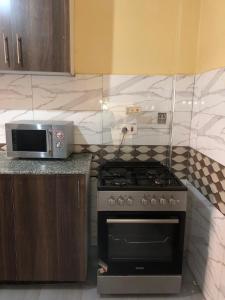 a kitchen with a stove and a microwave at Kisumu Airview Homestay in Kisumu