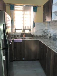 a kitchen with a black refrigerator and a sink at Kisumu Airview Homestay in Kisumu