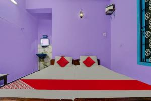 een slaapkamer met een groot bed met rode kussens bij OYO Sri Sivasakthi A/C Lodge in Sivakāsi