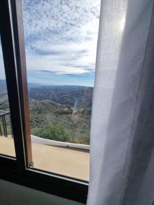 een raam met uitzicht op de bergen bij Apartamento Comares in Comares