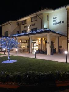 a building with a tree in front of it at night at Ca' Del Diaolo in Badia Calavena