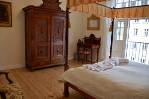 a bedroom with a bed and a large wooden cabinet at Rent a Room Copenhagen in Copenhagen