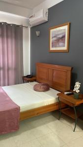 a bedroom with a bed and a nightstand and a bed sidx sidx at Felicidade Hotel in Praia