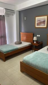 1 dormitorio con 2 camas y una lámpara en una mesa en Felicidade Hotel en Praia