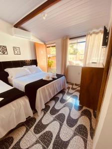 um quarto de hotel com duas camas e uma janela em Residencial Costa Mar em Rio das Ostras