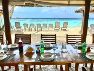 - une table sur la plage avec vue sur l'océan dans l'établissement RAINIKA VILLA, à Thinadhoo
