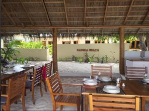 a dining room with tables and chairs in an outdoor area at RAINIKA VILLA in Thinadhoo
