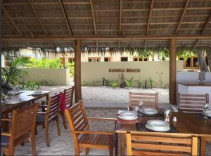 een eetkamer met tafels en stoelen in een buitenruimte bij RAINIKA VILLA in Thinadhoo