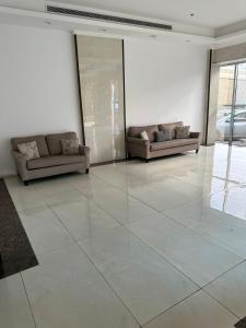a living room with two couches and a large tile floor at كيان حراء للشقق المخدومة- Kayan Hiraa Serviced Apartments in Jeddah