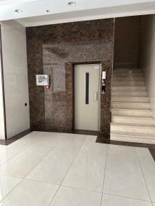 a hallway with a door and stairs in a building at كيان حراء للشقق المخدومة- Kayan Hiraa Serviced Apartments in Jeddah