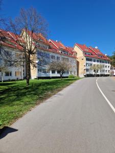 an empty road in front of two large buildings at Nidos centre 3 kambarių butas in Nida +10 photos