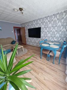 a living room with a blue table and chairs at Nidos centre 3 kambarių butas in Nida
