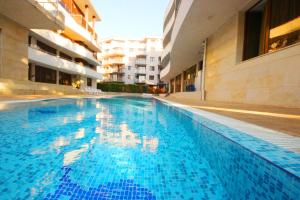 陽光海灘的住宿－Eden - Menada Apartments，大楼里的一个大型蓝色游泳池