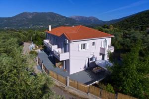 a white house with a red roof and a fence at Orchid Garden Apartment in Sami