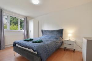 a bedroom with a bed with a night stand and a window at Contractor accommodation in Heeley