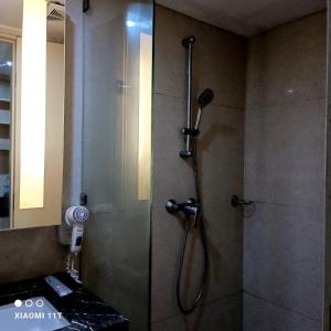 a shower with a glass door in a bathroom at Apartment Louise kienne in Semarang