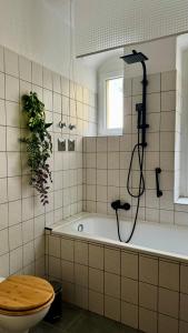 een badkamer met een bad, een douche en een toilet bij Noy´z in der belebten Neustadt in Dresden