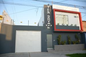 a building with two white doors and a sign on it at Villa Santa in Chiclayo