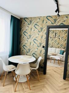 ブレズノにあるAPARTMÁN STYLE Breznoのテーブル、椅子、鏡が備わる客室です。