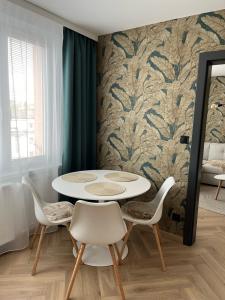een eetkamer met een witte tafel en stoelen bij APARTMÁN STYLE Brezno in Brezno